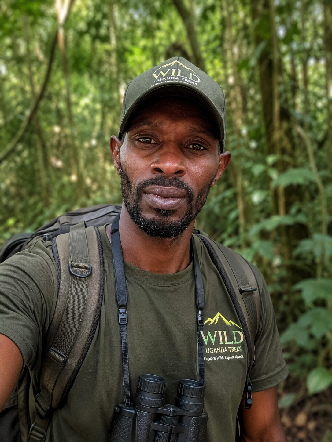 Herbert Muzoora, co-founder of Trek Wild Uganda, in Trek Wild Uganda branded cap and shirt in the forest